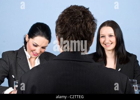 Business people having a job interview with a man and one of woman writting on paper and the other woman listening him Stock Photo