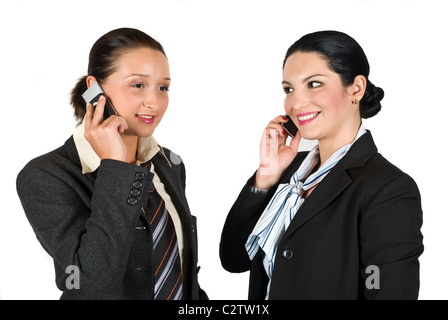 Two beautiful young business woman speaking both at cell phone and laughing isolated on white background Stock Photo