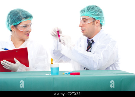 Team of two scientists people examine blood tube .Man pointing on tube and woman writing in clipboard Stock Photo