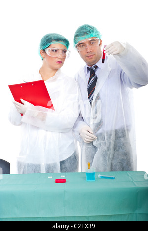 Team of two researchers people examine blood tube and woman taking notes in clipboard in a laboratory Stock Photo