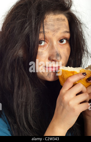 Close up of hungry beggar woman holding piece of bread and preparing to eat Stock Photo