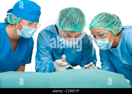 Three surgeons wearing sterile uniforms and being in operation isolated on white background Stock Photo