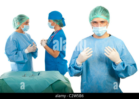 Surgeon in uniform ready for operation and his team having conversation in background Stock Photo