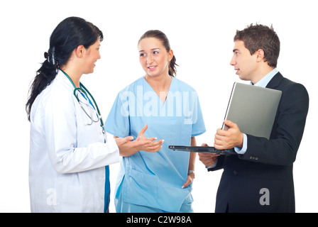 Young executive man holding a laptop and having a conversation with two physicians women Stock Photo
