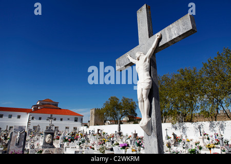 A representation of Jesus Christ on a crucifix is part of a grave in a graveyard. Stock Photo