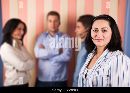 Support operator teamwork with mid female in front of image and her team in background Stock Photo