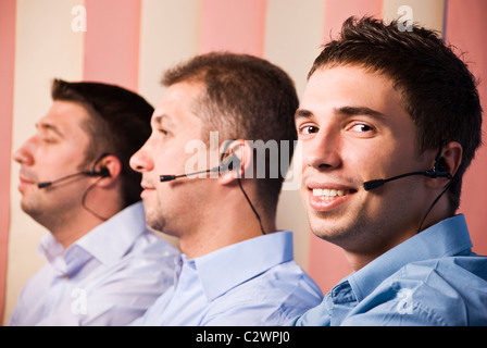Call center operators with three men team at work in office,first man facing camera and smiling Stock Photo