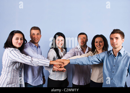 United big group of six business people standing with their hands together in front of blue background,,concept of team spirit Stock Photo