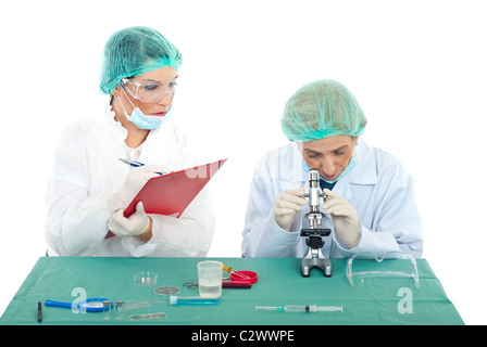 Two chemists women working in laboratory,the young woman taking notes in clipboard while the older woman looking Stock Photo