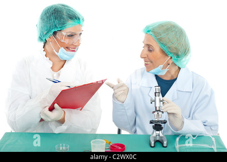 Senior teacher woman having conversation with her student in laboratory and both laughing Stock Photo
