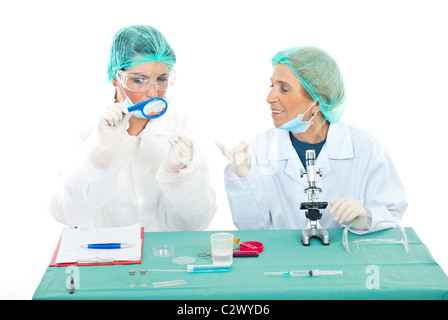 Senior woman teaching a student to use magnifying glass in laboratory Stock Photo