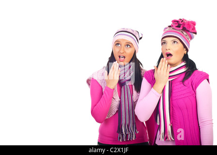 Two amazed girls wearing pink woolen clothes and looking up isolated on white background,copy space for text message Stock Photo