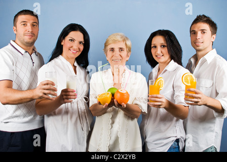 Healthy group of friends people or family persons standing in a line and holding different fruits, fresh orange juice or milk Stock Photo