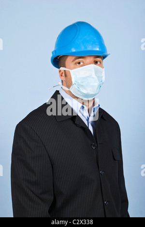 Young architect man standing in profile ,facing you and wearing helmet and protective mask,concept of protection from flu Stock Photo