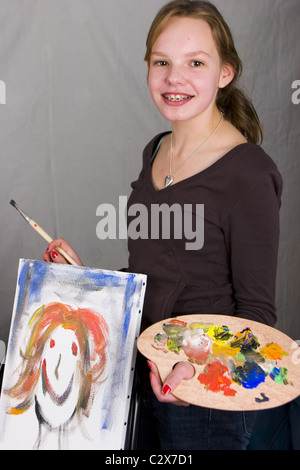 Teenager painting with canvas and palette in hand