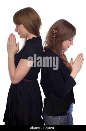 Two girls standing back to back at the time of prayer Stock Photo