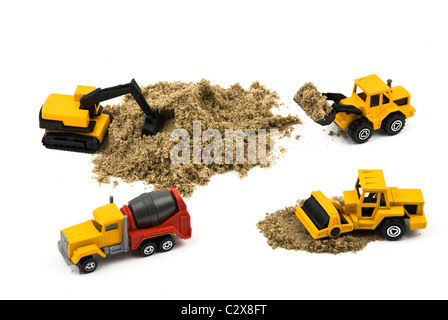 Trucks miniature working with sand isolated on white background Stock Photo