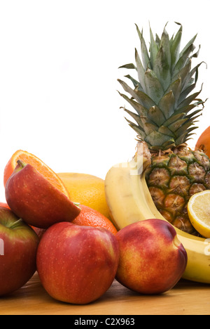Healthy fresh fruits whole or sliced on a wood table isolate don white background Stock Photo