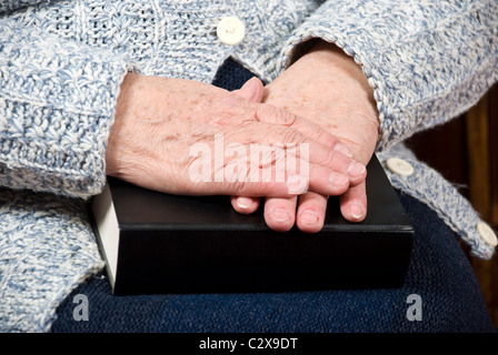 Elderly woman hands resting on a bible Stock Photo