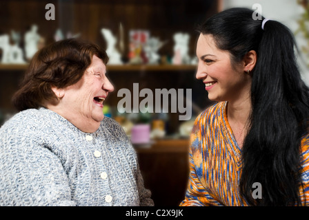 Grandma and her granddaughter having a happy conversation and both laughing together Stock Photo