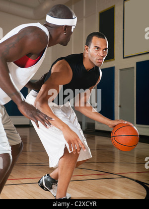 Men playing basketball on basketball court Stock Photo