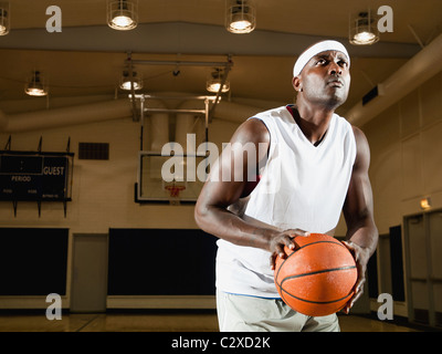 Black man shooting basketball on basketball court Stock Photo