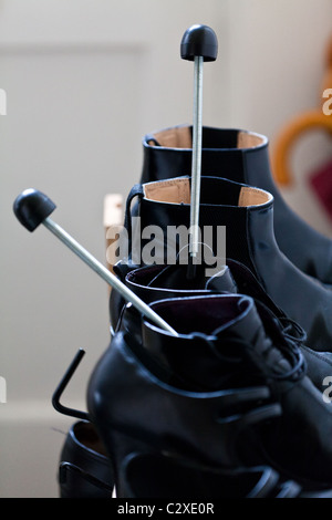 Shoe rack with black shoes and boots, on a wooden floor, besides a ...