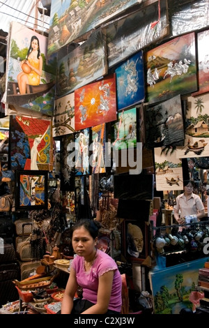 A woman is working at a colorful art store inside the Russian Market in Phnom Penh, Cambodia. Stock Photo