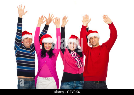 Four excited people friends wearing Santa hats and colorful clothes and standing with arms up and laughing together isolated Stock Photo