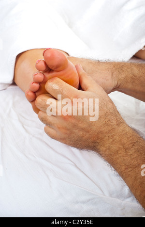 Health worker giving reflexology massage to woman feet Stock Photo