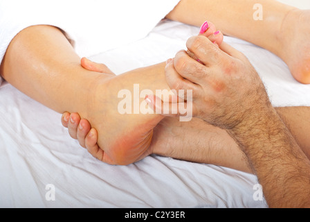 Health care worker giving orthopedic massage to woman feet Stock Photo
