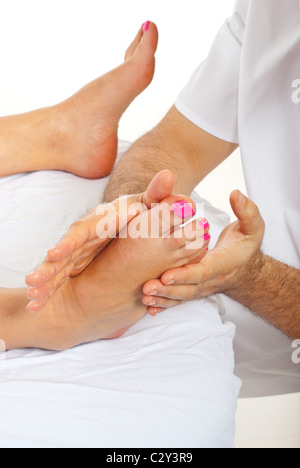Masseur man massaging woman feet and making pressure at spa salon Stock Photo