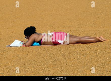 woman relaxes by reading  on the beach Sandy Point Beach in Sandy Point, Maryland Stock Photo