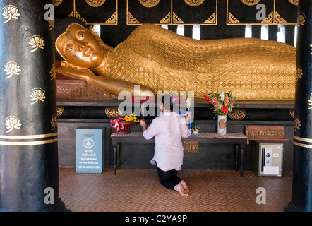 praying at sleeping golden Buddha image at Wat Chedi Luang Temple in Chiang Mai, Thailand Stock Photo