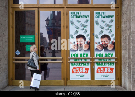 Customer entering bank, advertising poster with actor Antonio Banderas surrounded by zloty bank notes in Wrocław, Poland Stock Photo