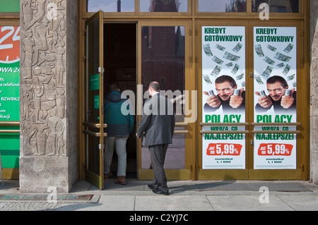 Customer entering bank, advertising poster with actor Antonio Banderas surrounded by zloty bank notes in Wrocław, Poland Stock Photo