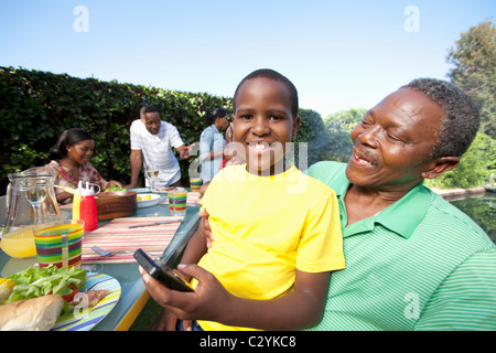 Boy teaching grandfather how to use mobile phone, Johannesburg, South Africa Stock Photo