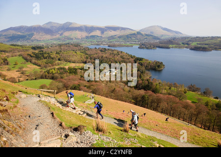 People hikers hiking on path up Catbells fell with a view to Derwentwater in Borrowdale in Lake District National Park Cumbria England UK Stock Photo