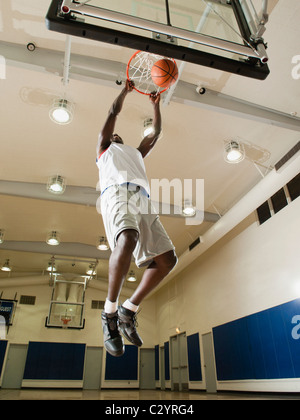 Black man shooting baskets on basketball court Stock Photo