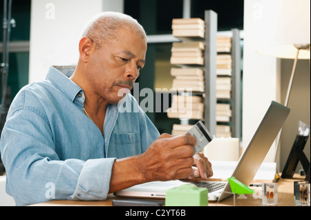 Black man shopping on line with credit card Stock Photo