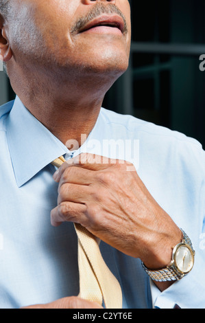 Black man adjusting tie Stock Photo