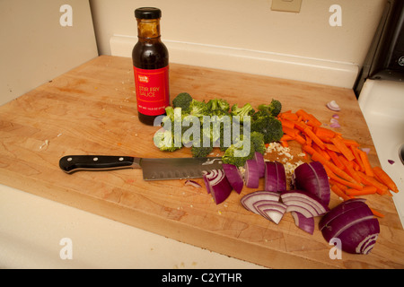 Cut up vegetables ready to be stir fried with a bottle of stir fry sauce Stock Photo