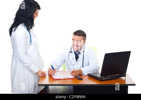 Two doctors having happy conversation in office and the man writing in his clipboard Stock Photo
