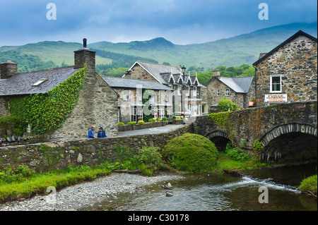 Tourists in village of traditional Welsh stone cottages with Welsh slate roofs, Beddgelert, Gwynedd, Wales Stock Photo