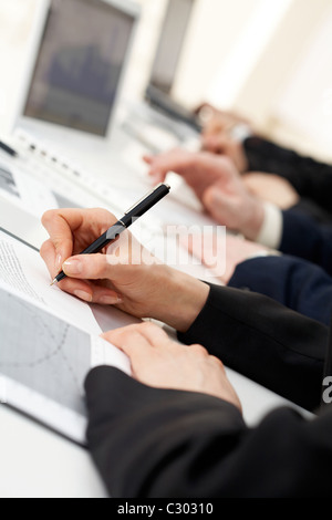 Image of human hand writing on paper at seminar or conference Stock Photo
