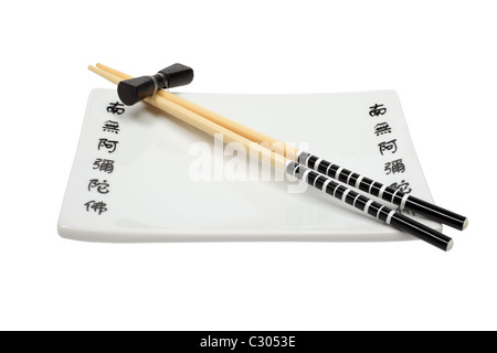 Unused asian chopsticks and plate isolated on white background. Stock Photo