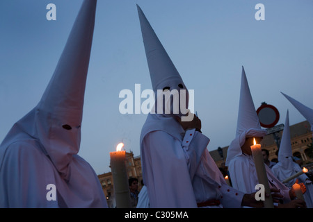 Hooded penitents (Nazarenos) in candlelit procession during Seville's annual Easter Holy Week (Semana Santa de Sevilla) Stock Photo