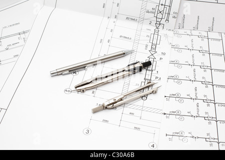 Measurement and drawing tools on white and black Russian blueprints. Mechanical pencil and steel compasses Stock Photo