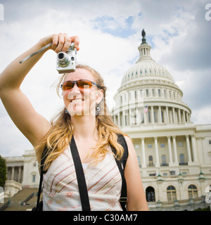 Woman taking a digital picture in front of the US Capitol building, Washington DC, USA. Stock Photo