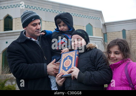Family with Quran Outside Mosque Stock Photo